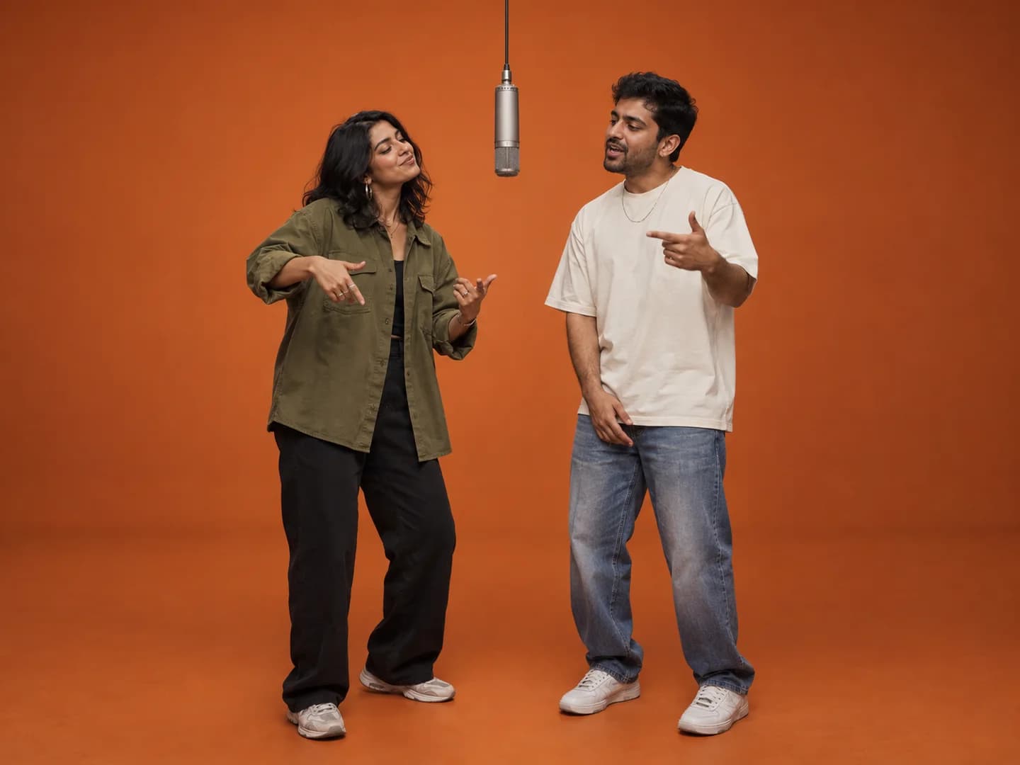 A couple sharing a hanging microphone for an orange-studio duet